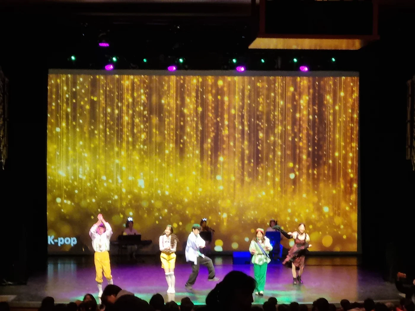 화려한 골드 조명 아래 펼쳐지는 K-POP 싱어롱 무대